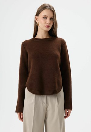 Brown knitted sweater with a round neckline and long sleeves, featuring a relaxed fit and ribbed hem, paired with light beige trousers.
