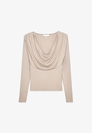 Ilgų rankovių marškiniai šviesiai beige spalvos. Yra su drapiruota apykakle ir aptemptu siluetu. Pagaminti iš minkštos, tamprios medžiagos su raukšlėtu paviršiumi.