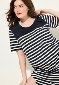 Randig t-shirtklänning med marinblå och vita horisontella ränder, korta ärmar och rundad halsringning, tillverkad av mjukt, strukturerat tyg.