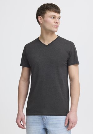 Camiseta de cuello en V de color gris oscuro, hecha de una tela suave, con mangas cortas y un corte ajustado, combinada con jeans de color azul claro.