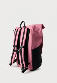 Ροζ σακίδιο με μαύρο κάτω μέρος. Διαθέτει ρυθμιζόμενους ιμάντες, κλείσιμο τύπου ρολό και πλαϊνή τσέπη από δίχτυ. Κατασκευασμένο από ανθεκτικό ύφασμα.