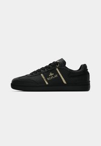 Black sneakers with textured upper, gold accents, and black rubber sole. Features logo detailing and flat black laces.