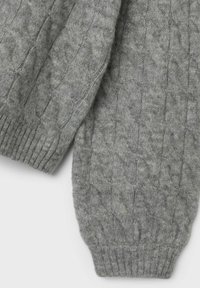Grå stickad tröja med en texturerad kabelmönster och ribbade ärmar. Mjuk material med en något fluffig utseende.