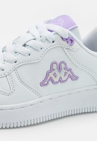 Fehér bőr sneaker lila kiegészítőkkel, texturált talppal, hímzett logóval és lapos fűzős kialakítással. Simára csiszolt felület finom varrási részletekkel.