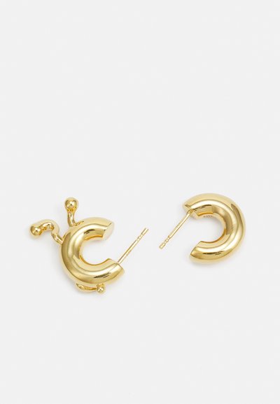 Gouden ringoorbellen met een gebogen ontwerp en extra ronde accenten. Vriendelijke textuur en glanzende afwerking, bevestigd met een post.