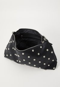 Sac à main noir avec des clous en argent, fermeture éclair, et doublure intérieure texturée. Comprend deux compartiments, dont une poche zippée.