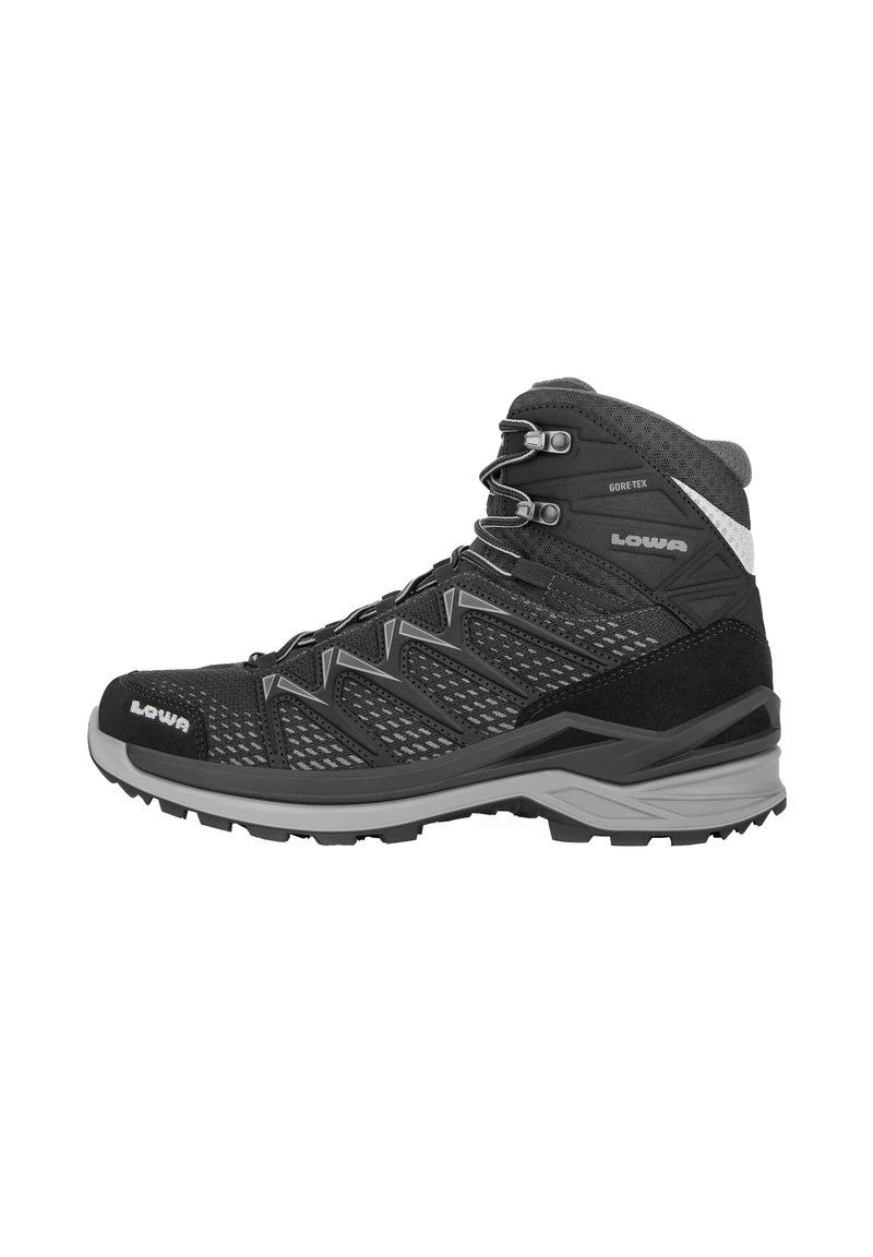 Bota de senderismo de corte medio en negro con acentos grises, que cuenta con un empeine de malla, una puntera de goma y una suela texturizada para tracción. Incluye forro GORE-TEX.