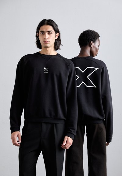 Black sweatshirt with white graphics; features a ribbed crew neckline, long sleeves, and relaxed fit. Back displays a large 'X' design.