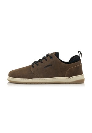 Zapato de ante marrón con lengüeta negra, cordones redondos, suela de color crema y asa. Presenta detalles cosidos y un logo en el lateral.
