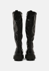 Schwarze wasserdichte kniehohe Stiefel mit glatter Oberfläche, verstärkten Nähten und grob profilierten Sohlen. Verfügt über einen seitlichen Reißverschluss und elastische Akzente.