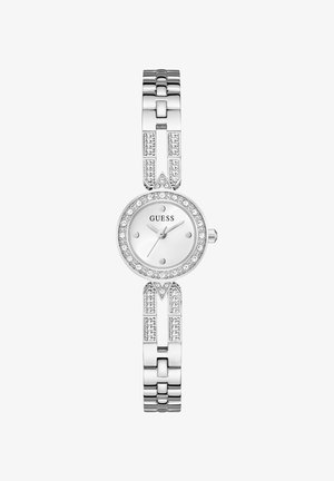 Montre-bracelet analogique pour femme Guess argentée avec lunette ornée de cristaux et maillons de bracelet décoratifs, cadran blanc et marqueurs minimalistes.