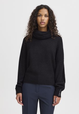 Pull noir à col roulé, avec une coupe décontractée, en tissu tricoté texturé, avec des accents de boutons sur les manches et un ourlet côtelé.