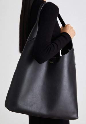 Černá kožená taška přes rameno s hladkou texturou, nadměrným tvarem a jedním ramenním poprukem. Obsahuje zlatý logo akcent.