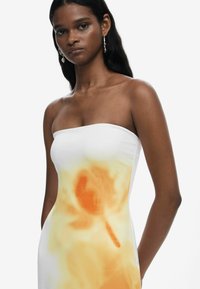 Strapless white dress featuring a gradient orange floral print, fitted silhouette, smooth texture, and structured design.