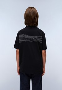 T-shirt noir à manches courtes, avec un motif de vagues grises et le texte "NAPAPIJRI" au dos, fabriqué en tissu doux avec une coupe décontractée.