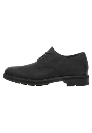 Czarny skórzany elegancki but sznurowany z niskim obcasem i okrągłym noskiem, widok z boku z wytłoczonym logo Timberland na obszarze pięty.
