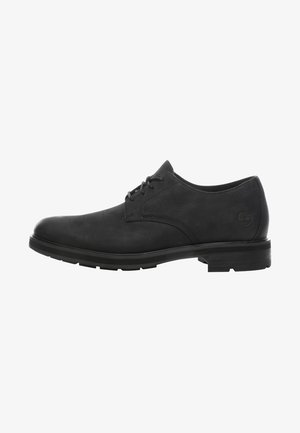 Czarny skórzany elegancki but sznurowany z niskim obcasem i okrągłym noskiem, widok z boku z wytłoczonym logo Timberland na obszarze pięty.