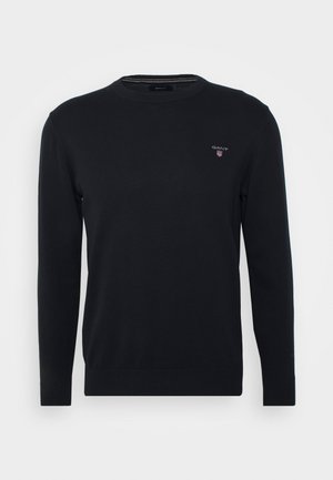 Pull noir à manches longues avec col rond, petit logo GANT et emblème de bouclier sur le côté gauche de la poitrine, poignets et ourlet côtelés.