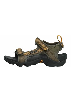 Teva-sandalen met een donkergroene bovenkant van stof met een camouflagepatroon, klittenbandsluitingen en een zwarte rubberen zool. Inclusief een trekband aan de achterkant.