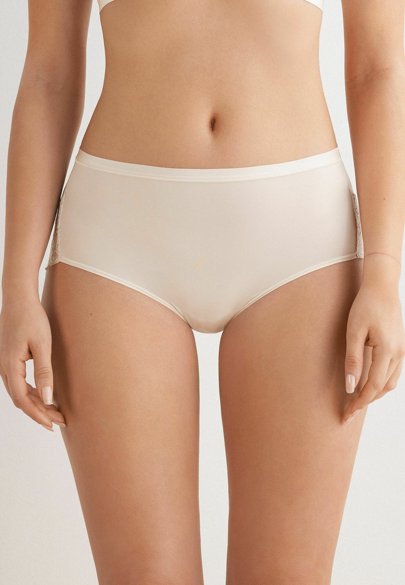 Beige High-Waist-Höschen mit glatter Oberfläche, seitlichen Spitzenpanelen und weichem elastischen Besatz. Es zeichnet sich durch eine Materialmischung für zusätzlichen Tragekomfort aus.