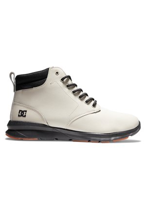 Hellbeiger High-Top-Sneaker mit schwarzem Kragen, schwarzen Schnürsenkeln, schwarzer Sohle und DC-Markenlogo an der Ferse.