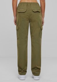 Olivegrüne Cargo-Hose mit lockerer Passform, ausgestattet mit Seiten- und Gesäßtaschen, einem elastischen Bund und einer glatten Baumwolltextur.