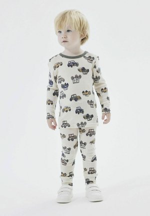 Children's pajamas in cream fabric featuring colorful vehicle patterns. The set includes a long-sleeve top and pants with a soft texture.