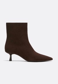 Bottines en daim marron avec un bout pointu et un talon aiguille pour une silhouette élégante. Texture lisse avec des détails de design minimaux.