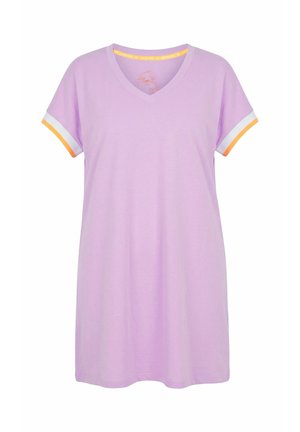 Kvinde i en knælang lavendelfarvet kjole med hvide og orange ærmekanter, der står barfodet i pink sandaler mod en hvid baggrund.