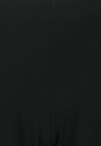 Schwarze Leggings aus einem glatten, elastischen Stoff. Zu den Funktionen gehören ein hoher Bund und flach genähte Nähte für Komfort und Langlebigkeit.