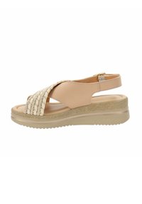 Sandal beige con tomaia intrecciata, cinturino posteriore regolabile e soletta testurizzata. Suola piatta in gomma con lieve elevazione e grip.
