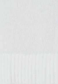 Weißer Strickpullover mit glatter Textur, mit gerippten Strickakzenten am Saum. Einfaches Design ohne sichtbare Muster oder Beschläge.