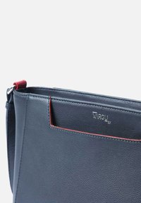 Donkerblauwe leren handtas met een gestructureerde afwerking, voorzien van een rode accenten, een zilveren logo en een verstelbare schouderband.