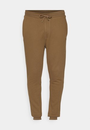 Pantalons de jogging marron en tissu doux, avec une taille à cordon de serrage, des jambes fuselées et des poignets élastiques. Design minimaliste sans motifs visibles.