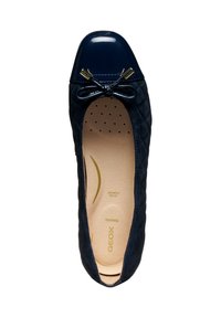 Ballerines navy avec un bout en vernis brillant, un nœud décoratif et une texture matelassée, avec une semelle intérieure rembourrée portant la marque visible à l'intérieur.