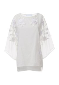 Blusa blanca transparente con mangas anchas, que presenta un intrincado bordado floral blanco y una tela suave y texturizada, creando una apariencia ligera y etérea.