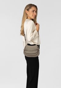 Borsa a tracolla in pelle grigio chiaro, caratterizzata da un design a più strati, ferrature argentate e tracolla regolabile. Texture liscia con accenti delicati.