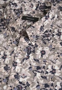 Kwiatowa koszula zapinana na guziki z lekkiego materiału. Charakteryzuje się małymi beżowymi, granatowymi i fioletowymi kwiatami na taupe tle. Zawiera cztery guziki.