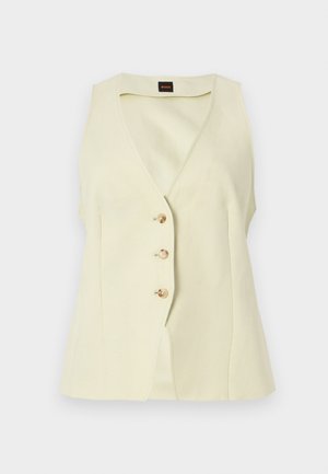 Αμάνικο γιλέκο σε κρεμ χρώμα με V-λαιμόκοψη και τρία κουμπιά στο μπροστινό μέρος, εφαρμοστή γραμμή και μικρή μαύρη ετικέτα με λογότυπο στο εσωτερικό του γιακά.