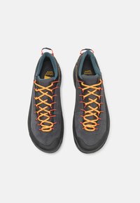 Graue Outdoorschuhe mit orangefarbenen Schnürsenkeln und schwarzen Gummisohlen. Sie verfügen über ein strukturiertes Obermaterial und einen gepolsterten Kragen mit türkisen Akzenten.