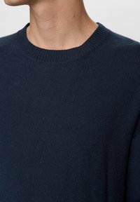 Marineblauwe gebreide trui met een ronde hals, voorzien van een gestructureerde stof en geribbelde details aan de manchetten en zoom, voor een casual uitstraling.