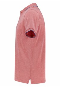 Polo rouge à manches courtes, texture douce, bordures bleues contrastantes au col et aux bords des manches, et une petite poche sur la poitrine.