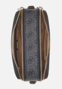 Borsa in tela nera con hardware dorato, doppia cerniera e motivo monogram. Presenta un interno beige con scomparti multipli.