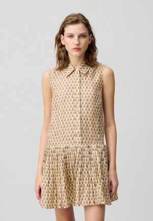 Abito senza maniche di un leggero beige con piccoli motivi floreali in bordeaux. Presenta una chiusura con bottoni sul davanti, colletto e una gonna arricciata. Texture liscia.