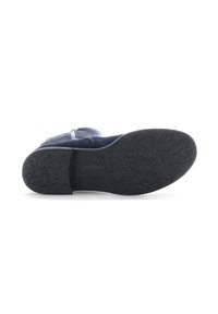Semelle de chaussure en caoutchouc noir avec motif texturé et marquage. Présente une légère courbe et des nervures pour une meilleure adhérence, conçue pour le confort et la durabilité.