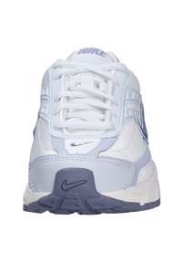 White and light purple Nike running shoe viewed from the front with laces and visible Nike swoosh logos on sole and tongue.