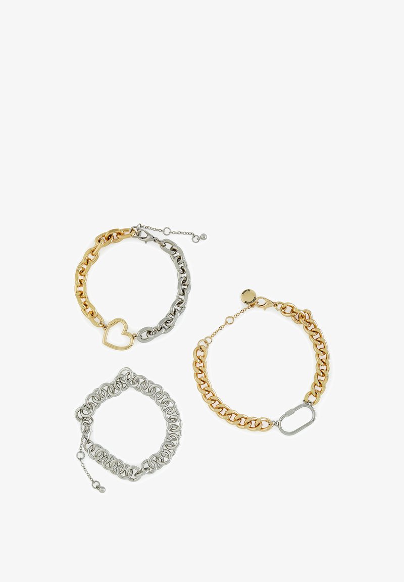 Tre braccialetti: uno in oro e argento con dettaglio a forma di cuore, uno in argento con un motivo attorcigliato, e uno in oro con una catena a maglie e chiusura ovale.