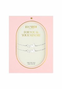 Zilveren bijpassende armbanden met vlinderontwerpen, gepresenteerd op een lichtroze kaart met gouden tekst en accenten. De tekst luidt: "Voor jou & je mini-me."