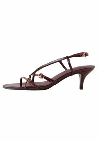 Burgundy patentoitu nahka korkokengät ohuilla remmeillä, pyöreillä metallikoristeilla ja hoikalla stilettokorkolla. Avoin varvasdesign.