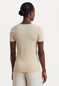 Striped short-sleeve t-shirt in beige and white, featuring a crew neck and a fitted silhouette, made from soft, breathable fabric.